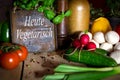 A lots of healthy vegetables on a wooden table, sign with text H