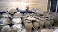 Lots of homemade pottery. Stock footage. Grey earthenware with many identical jars and plates on table in workshop