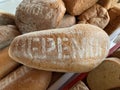 Lots of loaves of bread on the table. Concept: baking wheat to help people. Bread whole and cut into halves