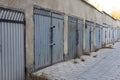 Lots of metal garage doors. Entrances to parking spaces for cars in the courtyard of an apartment building. Garage