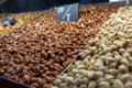 Lots of nuts on the counter at the fair, market, salted caramel almonds, fried pistachios. Concept for a healthy outdoor snack.