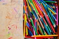 Lots of old colored wooden pencils in a cardboard box with children`s doodles Royalty Free Stock Photo