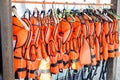 Lots of orange life jackets hanging on hangers Royalty Free Stock Photo