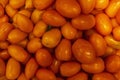 Lots of orange mashed tomatoes in a box in a store. Close-up. Top view. Poor quality unripe product Royalty Free Stock Photo