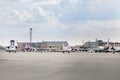 Lots of parked aircrafts in a parking area of a small airport