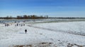 Lots of people are doing ice skating on the frozen meadows of the Rhine . After a slight flood and cold temperatures, ice surfaces