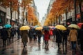 Lots of people with umbrellas and waterproof clothing. Street view on a rainy autumn day