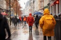 Lots of people with umbrellas and waterproof clothing. Street view on a rainy autumn day