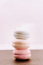 Lots of pink macaroons in a stack on a light background. Macro photography of a group of traditional French round