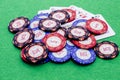 Pile of poker chips on four cards as winning hand