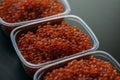 Lots of red caviar in jar. Sea food. Healthy eating. Red salmon caviar. Caviar in bowl over black background. Close-up. Royalty Free Stock Photo