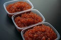 Lots of red caviar in jar. Sea food. Healthy eating. Red salmon caviar. Caviar in bowl over black background. Close-up. Royalty Free Stock Photo