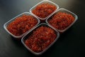 Lots of red caviar in jar. Sea food. Healthy eating. Red salmon caviar. Caviar in bowl over black background. Close-up Royalty Free Stock Photo