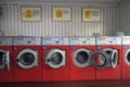 Lots of red washing machines in a self-service laundromat