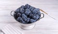 Lots of ripe juicy plums in a white bowl on the table Royalty Free Stock Photo