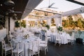 Wedding dinner table reception. Lots of round tables with white tablecloths and white Chiavari chairs. Restaurant Royalty Free Stock Photo