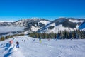 Lots of Skiers on a Wide and Gentle Ski Slope in Sunny Weather