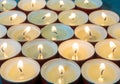 Lots of small lit candles. Dark mysterious atmosphere. Flat round candles
