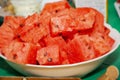 Lots of small pieces of watermelon on a white plate. Watermelon is a favorite fruit. The concept of food and drinks.