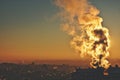 Lots of smoke coming out to the sky from a factory chimney. Looks like something is on fire. Moody pastel sunset colors Royalty Free Stock Photo