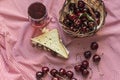 Lots of sour cherries and a toast bread sandwich on a plaid picnic blanket, still life photography