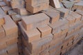 Lots of stacked paving stones, red, on a construction site. Close up.