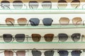 Lots of sunglasses in different shapes and colors on display in a store. Vacation and travel. Close-up. Front view