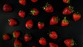 Lots of sweet, tasty and juicy garden strawberries, evenly distributed on a black background