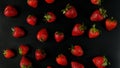 Lots of sweet, tasty and juicy garden strawberries, evenly distributed on a black background
