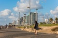 Lots tourist walking at the Sir Charles Clore park and background of tall skylines and luxury hotels along the Tel Aviv beach