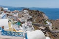 Lots of tourists on ruins. Tiny little white houses and long stairway in the Oia village at Thira Island, Greece.