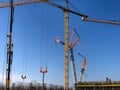 Lots of tower cranes against blue sky. Lifting machinery at construction site Royalty Free Stock Photo