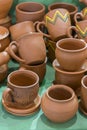 Lots of traditional ukrainian handmade clay pottery production. brown pottery. Clay plates and cups. vertical photo