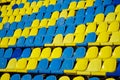 Lots of used blue and yellow plastic seats in an open stadium. Free access. Empty seats, without spectators. Waiting for the sight Royalty Free Stock Photo