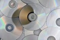 Lots of used laser CDs and DVDs on the surface of the table, technological background Royalty Free Stock Photo