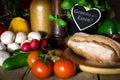 A lots of vegetables and bread on a wooden table, heart with te