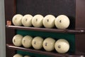 Lots white balls on the shelf-stand for billiard balls in one row for playing Russian Billiards. vintage cabin Russian