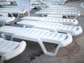 Lots of white empty sun loungers at the pool closeup at sunset Royalty Free Stock Photo