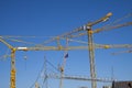 Lots of yellow cranes against a deep blue sky. Almost abstract composition with copy space Royalty Free Stock Photo