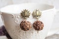 Indian seed earrings on white cup background