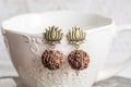 Indian seed earrings on white cup background