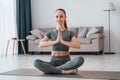 Lotus pose. Young woman with slim body type and in yoga clothes is at home