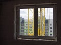 Loud construction site noise immission in opened one frame of white pvc window, view through