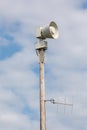 Loud speaker siren on a pole with cloudy sky in the background Royalty Free Stock Photo
