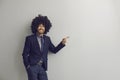Loudly laughing business man in funny afro curly hair wig pointing at something Royalty Free Stock Photo