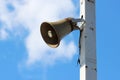 Loudspeaker on a pole in a railway station against a blue sky. Royalty Free Stock Photo