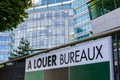 \'Offices for rent\' written in French on a sign outside a modern office building in France