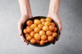 ALoukoumades or luqaimat or lokma in black bowl. Popular Ramadan or Ramazan Food. Iftar or Suhur sweets in female hands