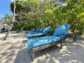 Lounge chairs or beach chairs on white sand beach in hot summer day in luxury tropical hotel Royalty Free Stock Photo