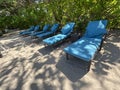 Lounge chairs or beach chairs on white sand beach in hot summer day in luxury tropical hotel Royalty Free Stock Photo